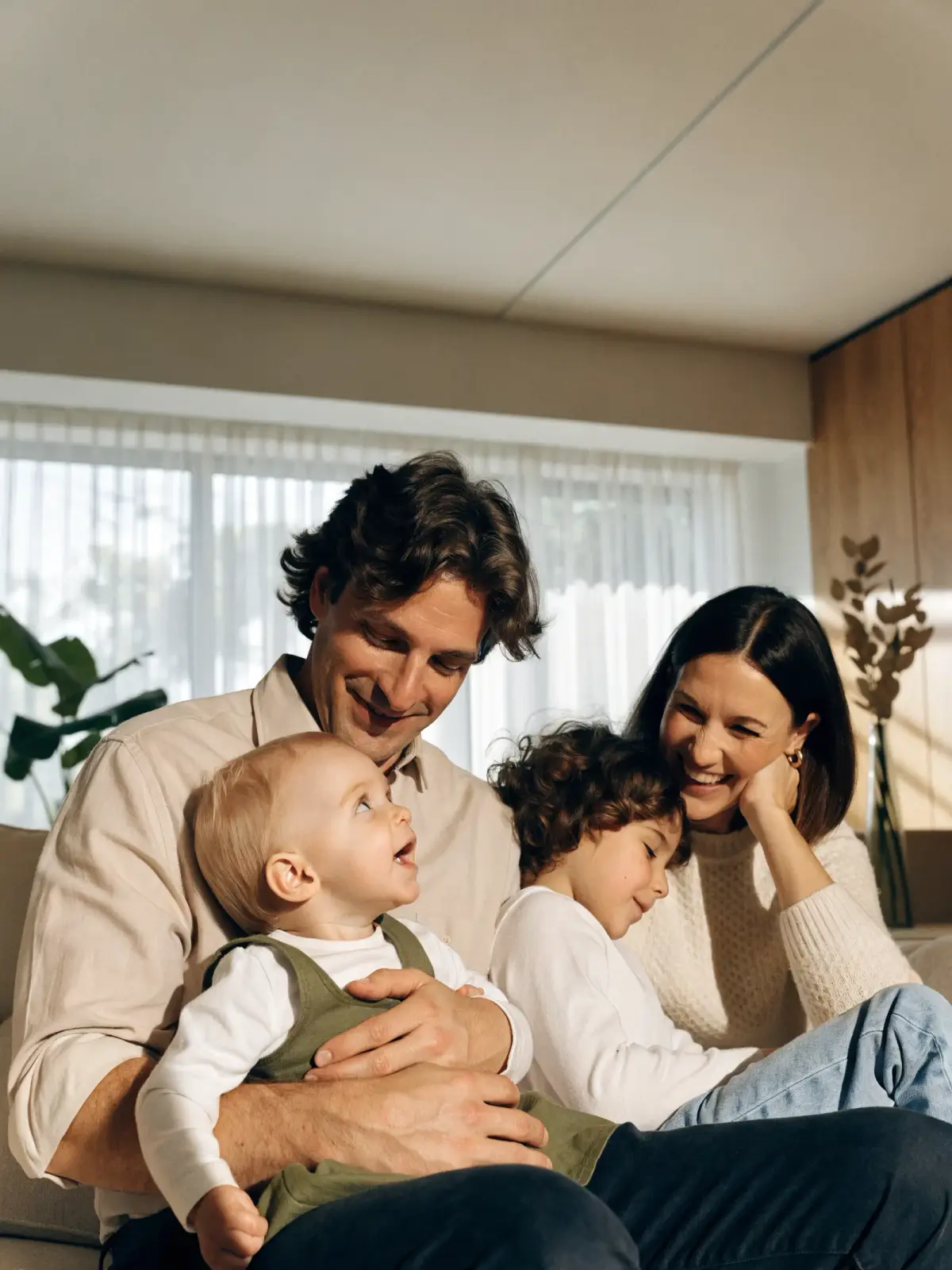Deux parents et leurs deux enfants, assis ensemble dans leur salon